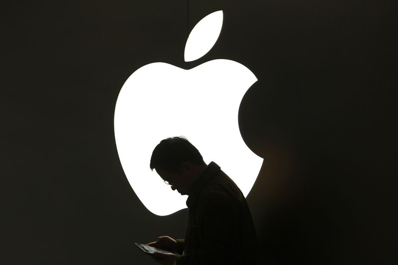 Apple No Ha Proporcionado Ninguna Solución Inmediata Y Concreta Para Abordar El Problema De Que Tanto Adultos Como Niños Acumulen Facturas Excesivas En Sus Tarjetas De Crédito Por Adquisiciones "in-app" (compras Integradas En Aplicaciones) En Tabletas Y Teléfonos Móviles, Dijo La Comisión Europea El Viernes.  En La Imagen, Un Hombre Mira Su IPad Frente A Un Logo De Apple En Shanghái El 16 De Marzo De 2012. REUTERS/Aly Song/Files